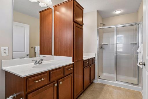 Primary bathroom includes separate vanities and walk in shower