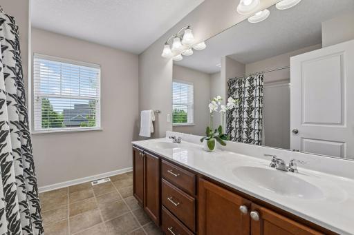 Full bath with a dual-sink vanity and shower/tub combo