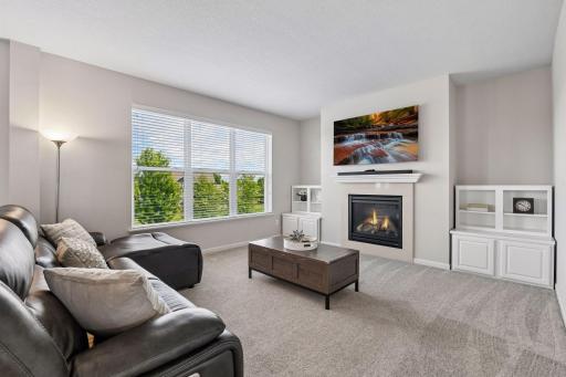 Living room anchored by a gas fireplace and filled with natural light