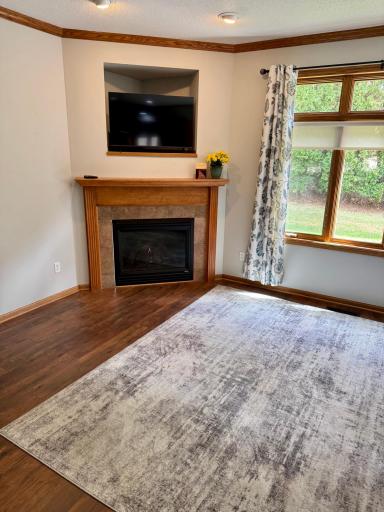 The beautifully updated living area centers around a cozy fireplace, perfectly complemented by the warmth of the new flooring, creating an instantly inviting and serene retreat.