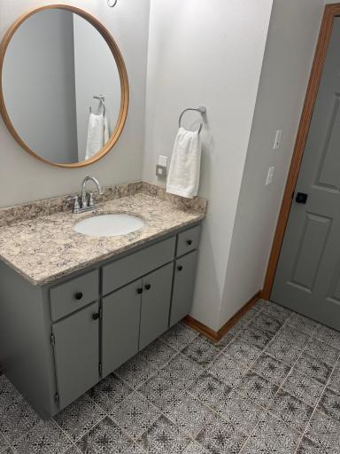 Modern and fresh, the bathroom has been thoughtfully updated with stylish tile flooring and luxurious quartz countertops.