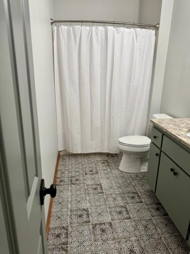 This beautifully updated bathroom offers a fresh, modern retreat, featuring chic, designer tile flooring and finished with elegant quartz countertops.