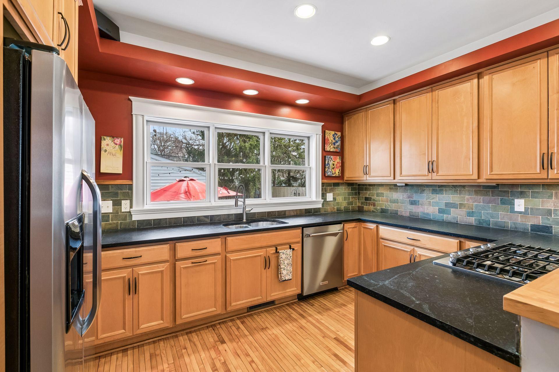 Gourmet kitchen with new stainless steel appliances,soapstone countertops and huge window looking out to very private yard.