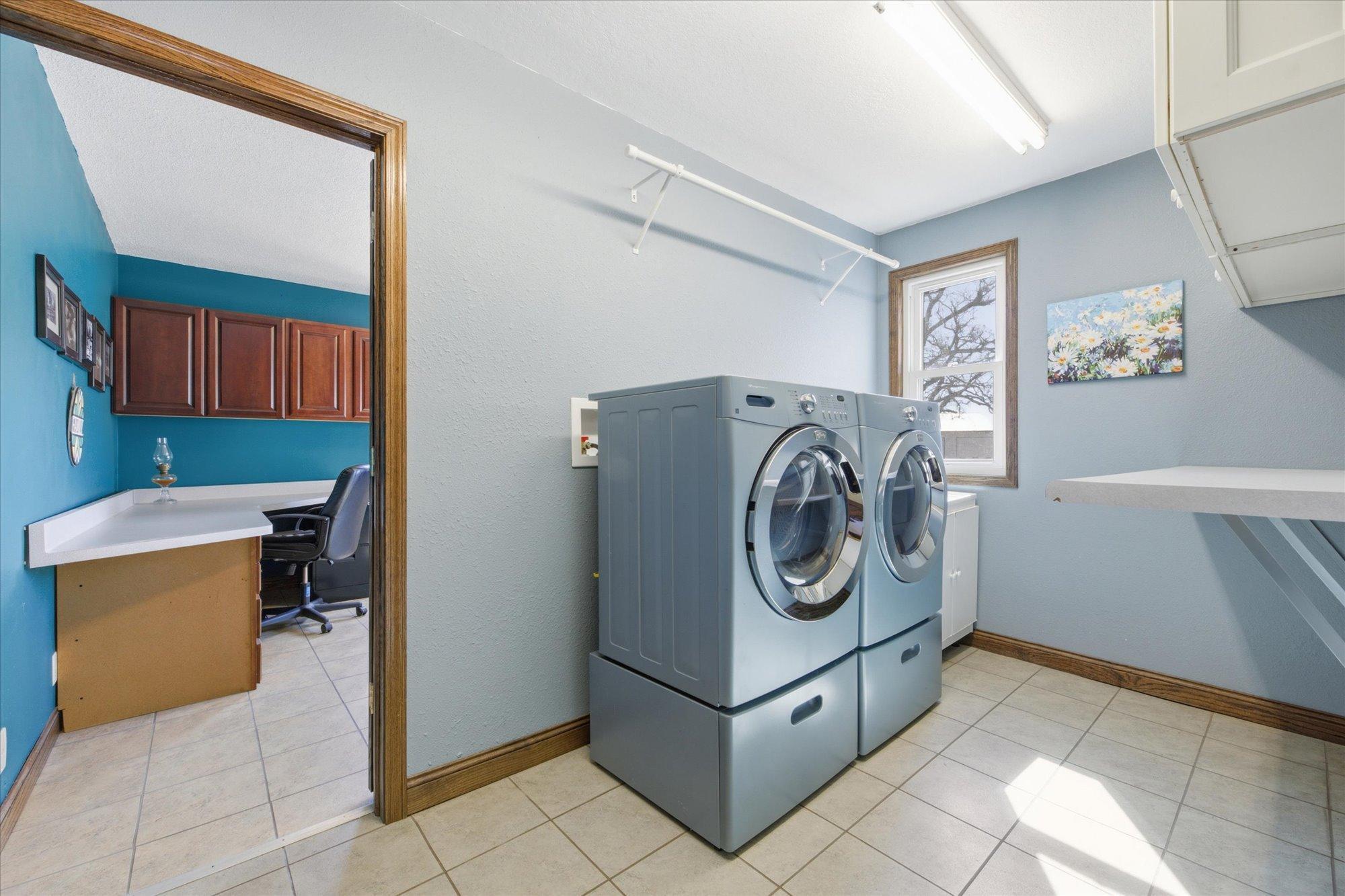 Main floor laundry features folding station, utility sink & built in ironing board.