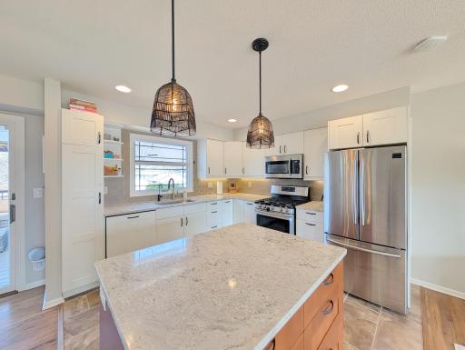 Stainless steel appliances plus a classy island with light fixtures make this kitchen stand out.