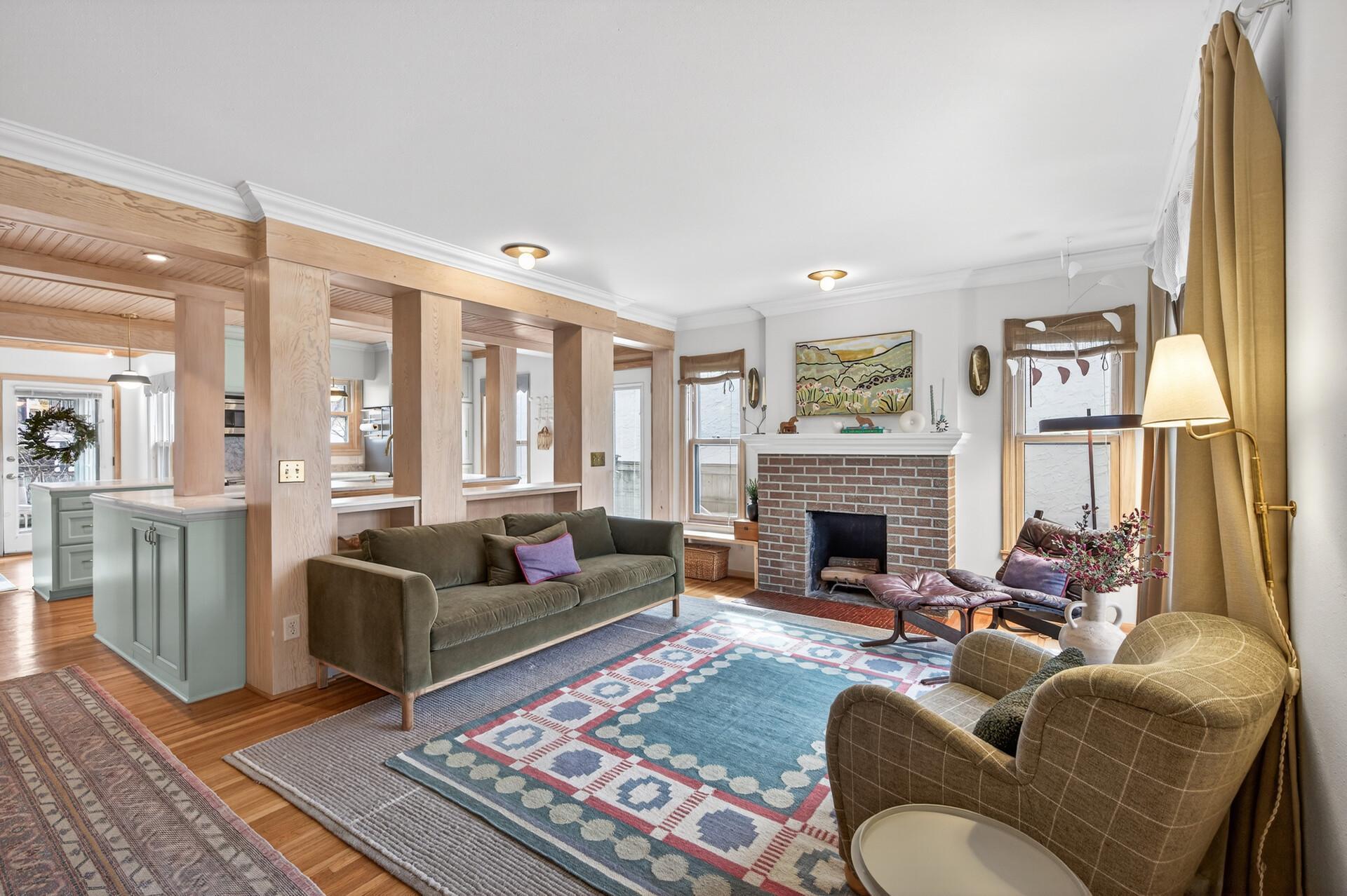 The charming living room is anchored by a stunning fireplace and boasts crown molding, beautiful hardwood floors, and loads of natural light