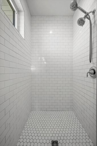 Walk-in tiled shower with a window, bringing in natural light and a spa-like feel