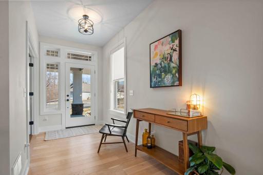 Bright and open foyer showcases the beautiful hardwood floors and has an office space off to the right