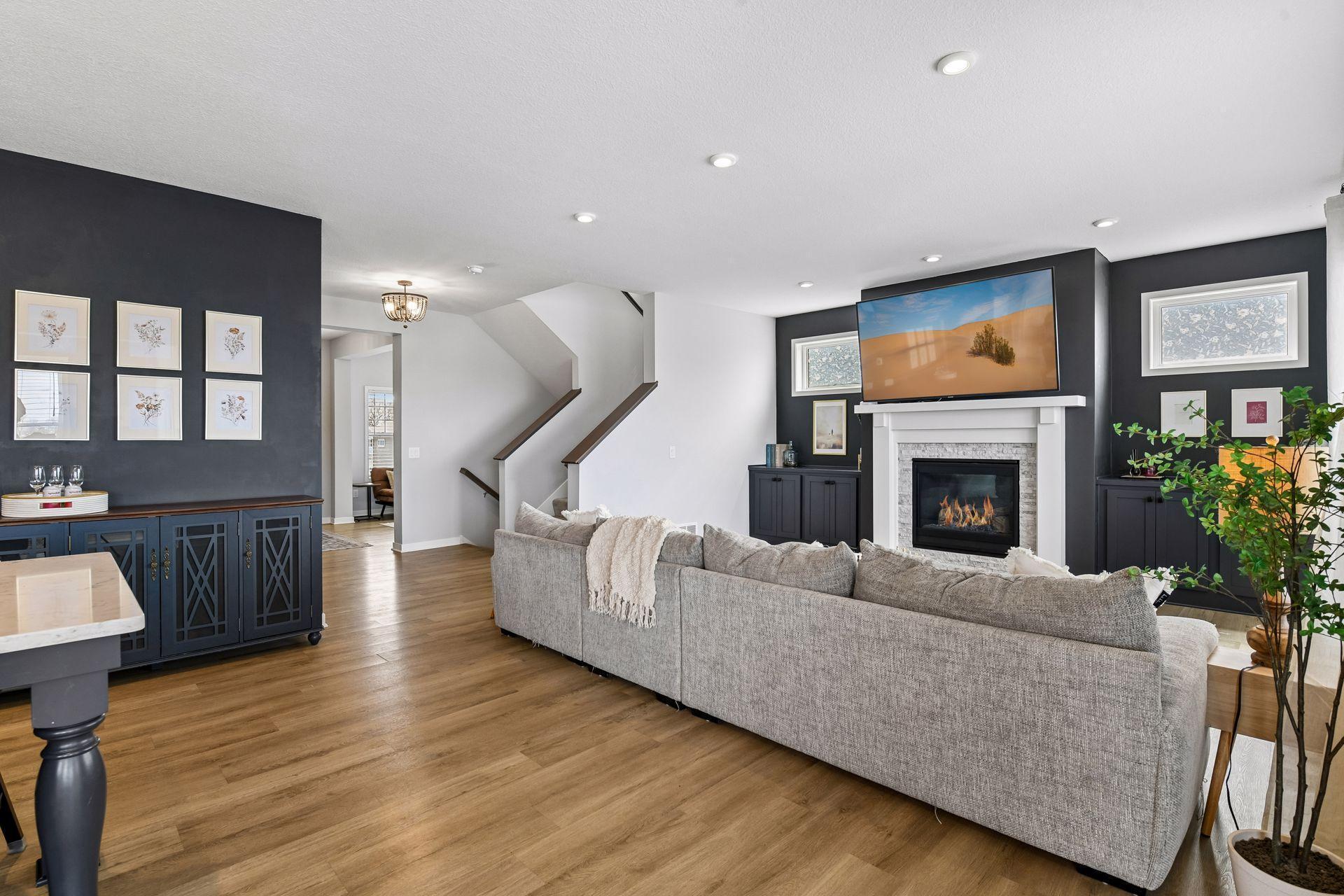 Open living room with fireplace, LVP floors, and stair lighting, the kind of space that works for a quiet night in or a house full of people.