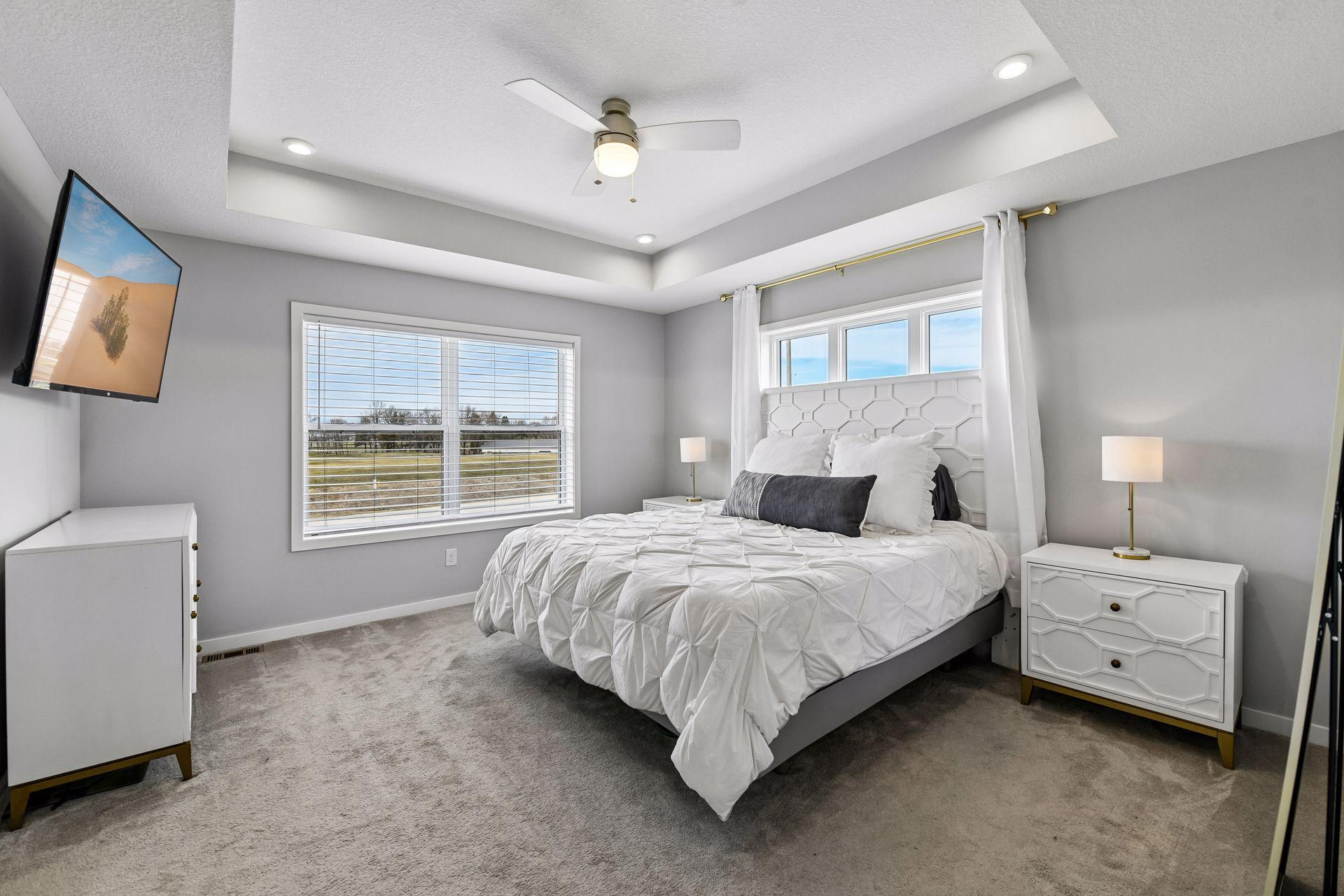 Spacious primary suite features tray ceiling and views of Lake Waconia