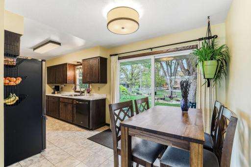 A cozy dining space sits just off the kitchen, bathed in natural light from the NEWER Anderson Windows sliding glass door (2018)