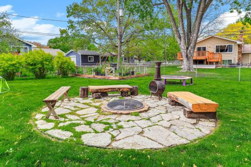 A beautifully crafted flagstone patio surrounds a built-in fire pit, creating a warm and inviting outdoor gathering space.