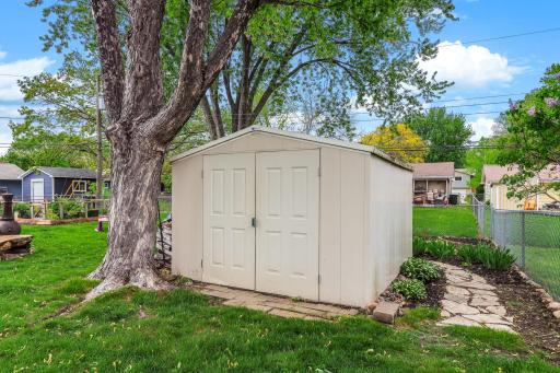 A well-kept storage shed sits neatly in the backyard, offering convenient space for tools, lawn equipment, and seasonal items.