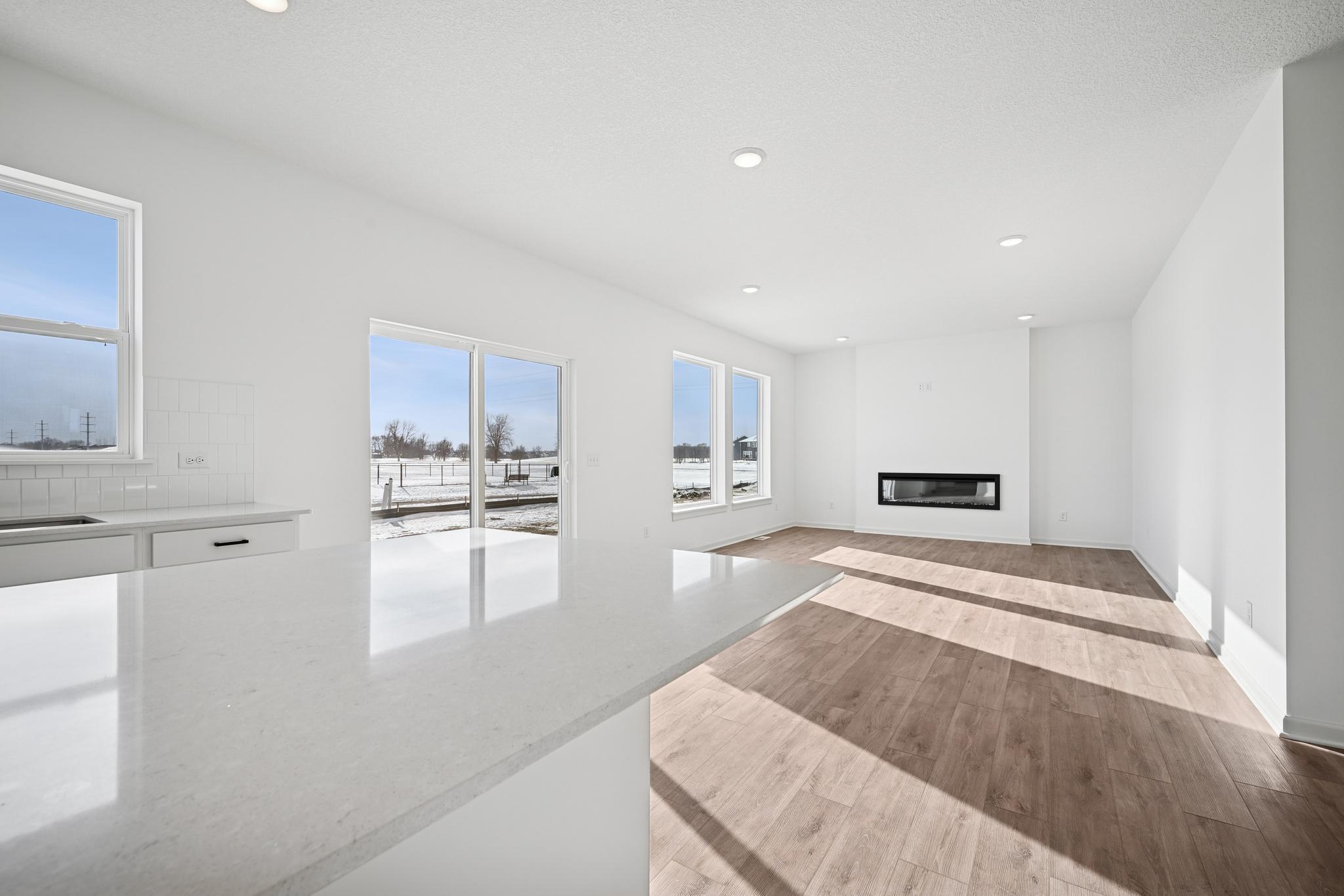 The open-concept family room is filled with natural light and enhanced by open sight lines that create a bright, inviting atmosphere. **Photo of similar home**