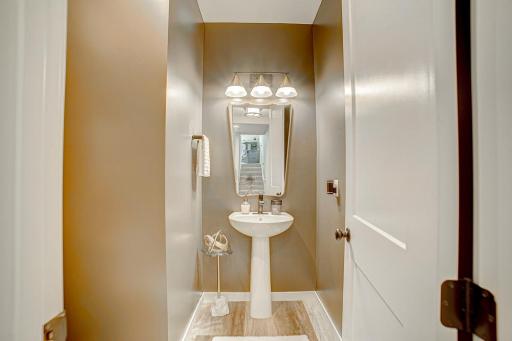 Main floor 1/2 bath with new paint, light fixture and mirror.