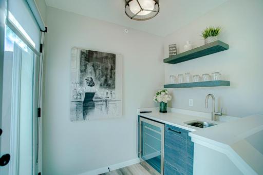 A wet bar and undercounter refrigerator at the top of the house. The perfect place to prep snacks and beverages before heading out to the rooftop deck space.