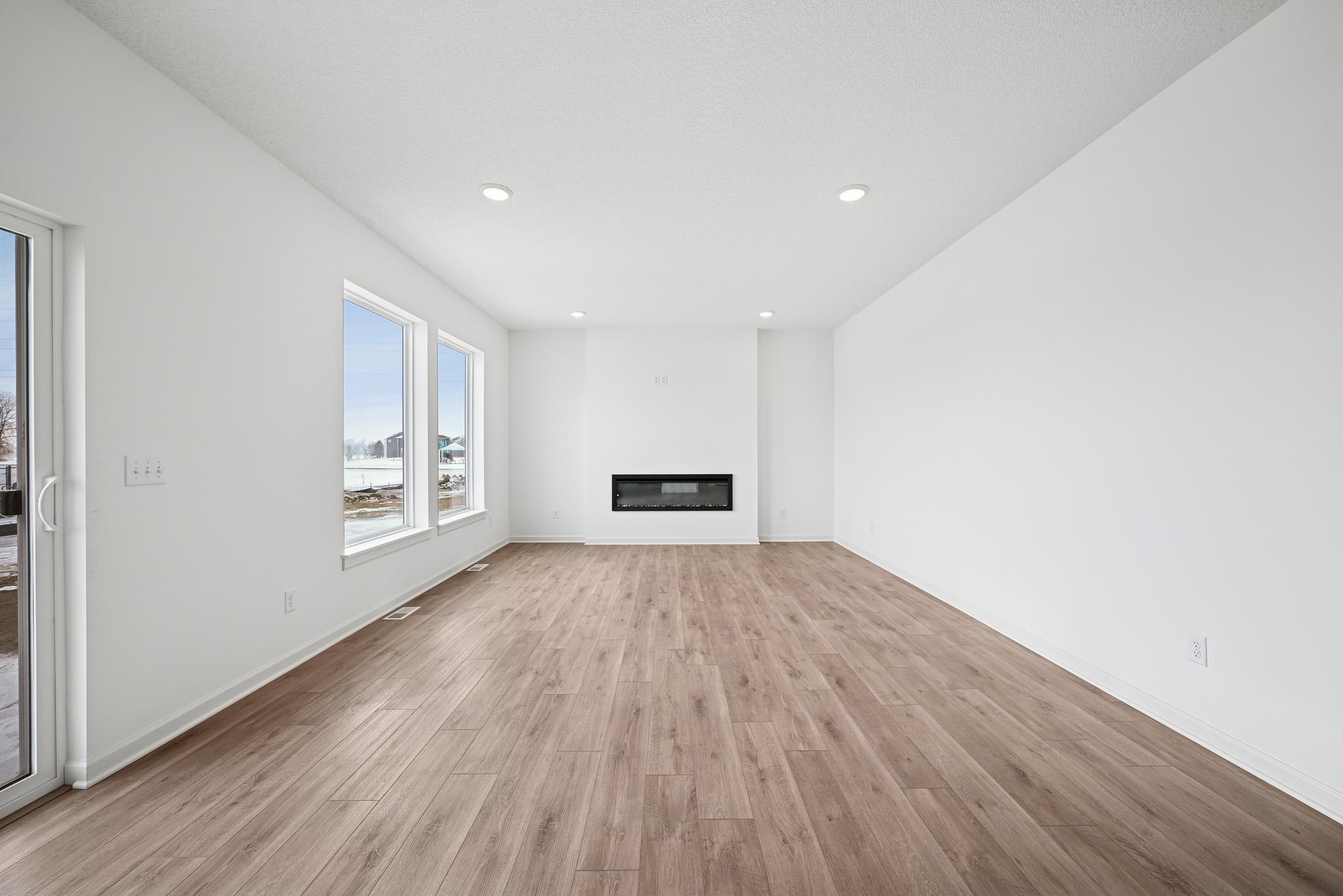 The open-concept family room is filled with natural light and enhanced by open sight lines that create a bright, inviting atmosphere. **Photo of similar home**