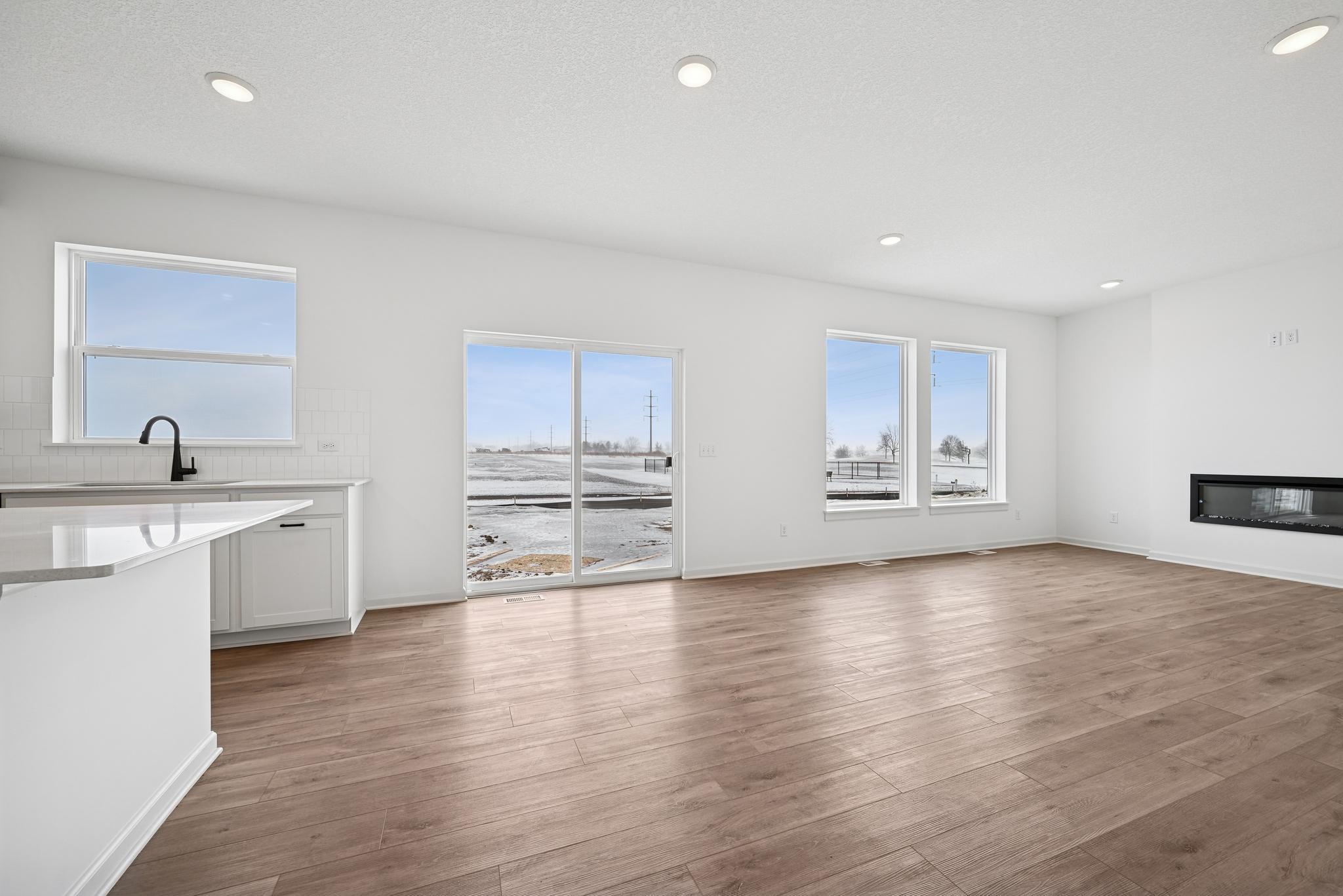 The open-concept family room is filled with natural light and enhanced by open sight lines that create a bright, inviting atmosphere. **Photo of similar home**