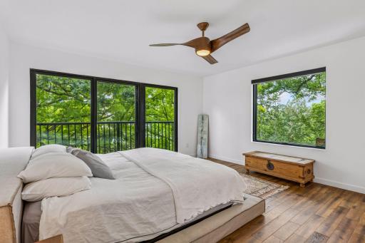 Primary bedroom with summertime tree top views and lake views in late fall/winter