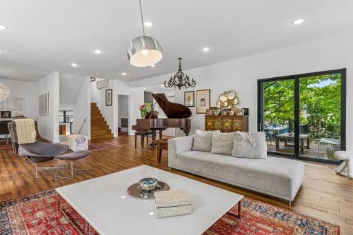 Living room with view to central stairway up/down and sliding doors to side deck
