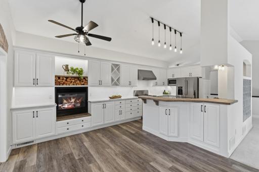 Kitchen offers enameled cabinetry that features raised panel doors, under and above cabinet
accent lighting, open wine bottle display, open shelves and raised breakfast bar
with a rustic reclaimed wood top