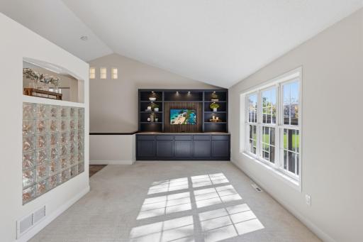 Living Room features built-in entertainment cabinetry that offers storage, display shelving with accent lighting and large wood paneled opening for a modern size TV