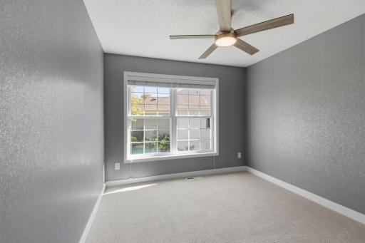 Bedroom 3 features ceiling fan, new carpet and decorative wall treatment