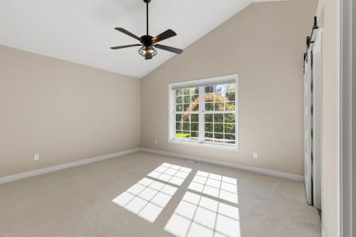 Master Bedroom features vaulted ceilings with fan, new carpet and windows that capture treetop views of the naturally private property