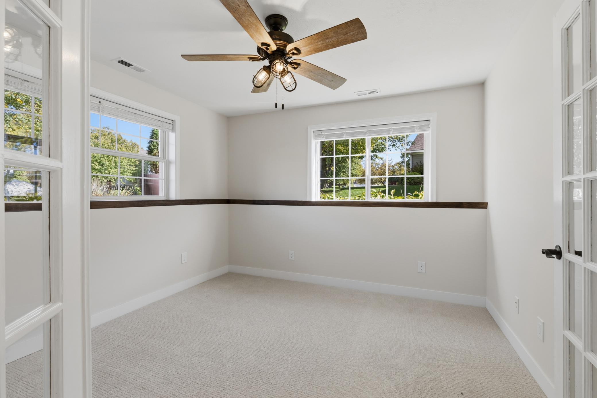 Bedroom 4 features full glass French doors, ceiling fan and abundance of windows