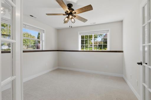 Bedroom 4 features full glass French doors, ceiling fan and abundance of windows