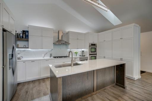 The modern kitchen features stainless steel appliances, a spacious center island, and abundant counter and cabinet space.
