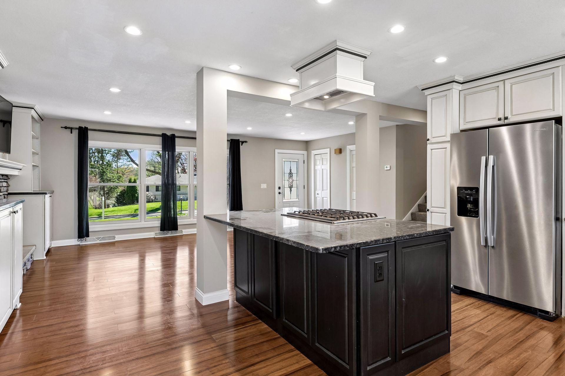 The center island provides a gas range with overhead vent and seating.