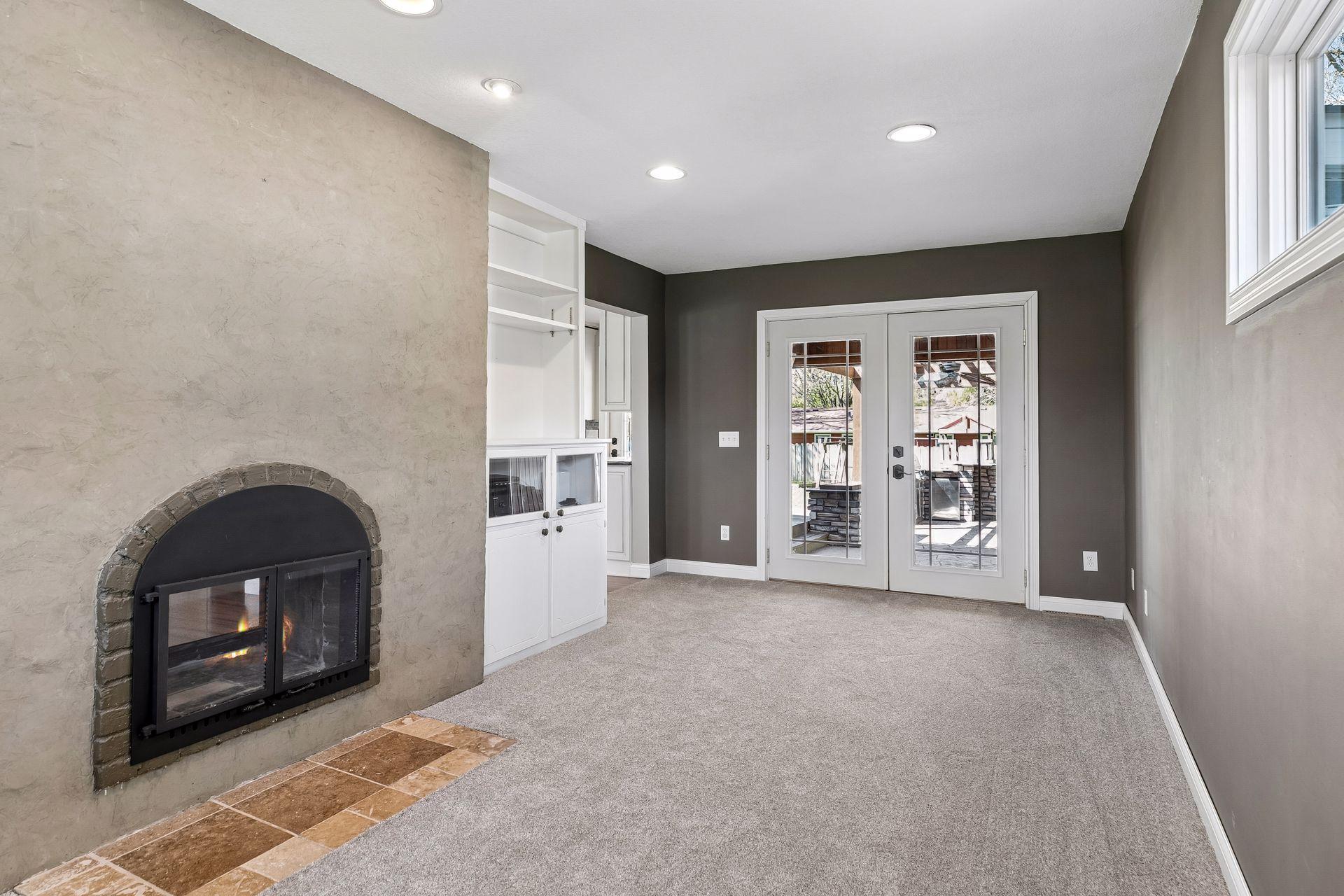 Space offers built-ins, 2 sided fireplace shared with the living room, French doors to rear covered porch and outdoor kitchen/patio area.