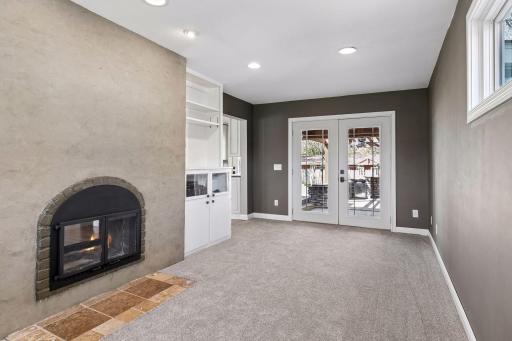 Space offers built-ins, 2 sided fireplace shared with the living room, French doors to rear covered porch and outdoor kitchen/patio area.
