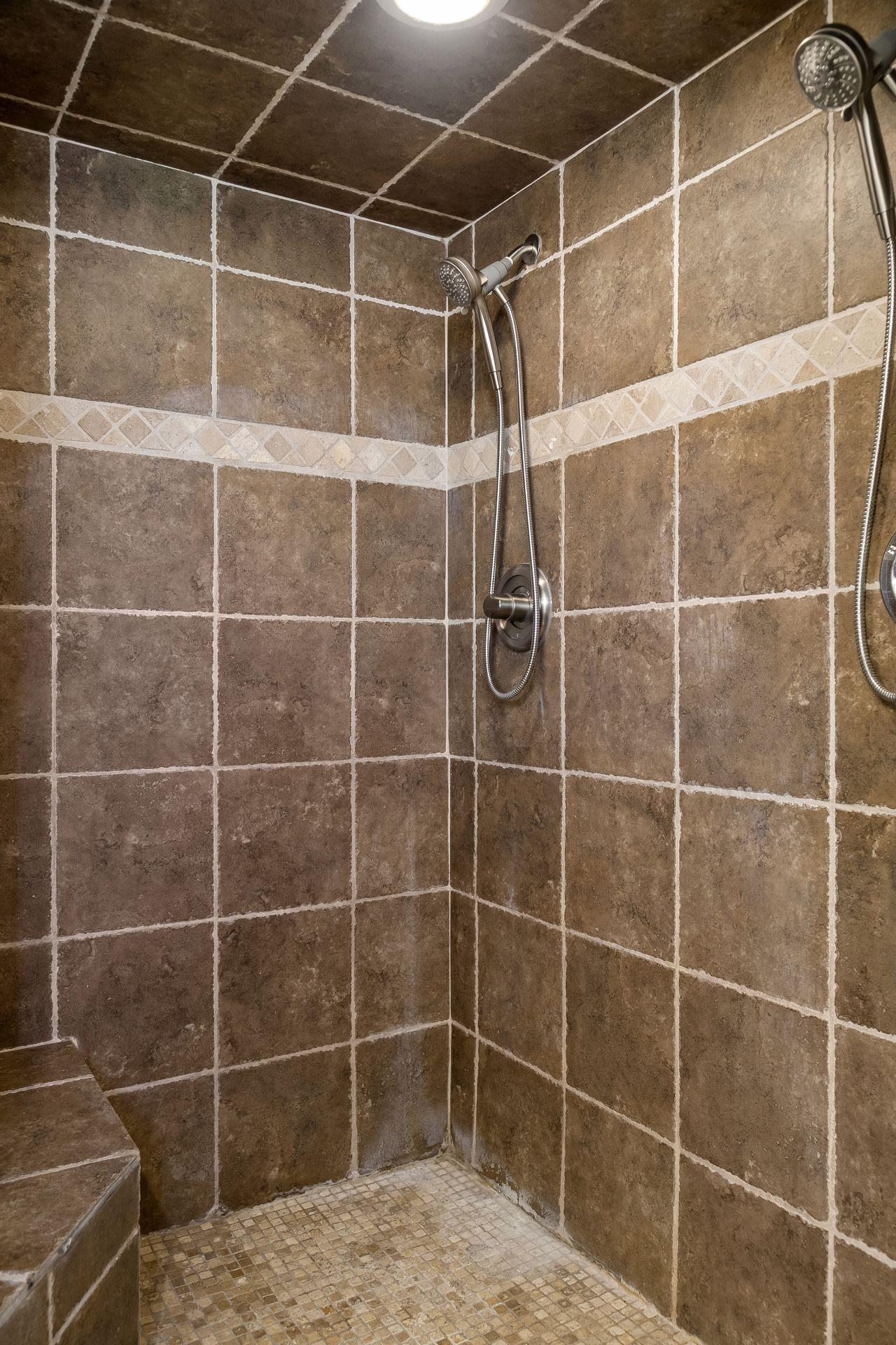 Floor to ceiling tiled shower with dual shower heads.