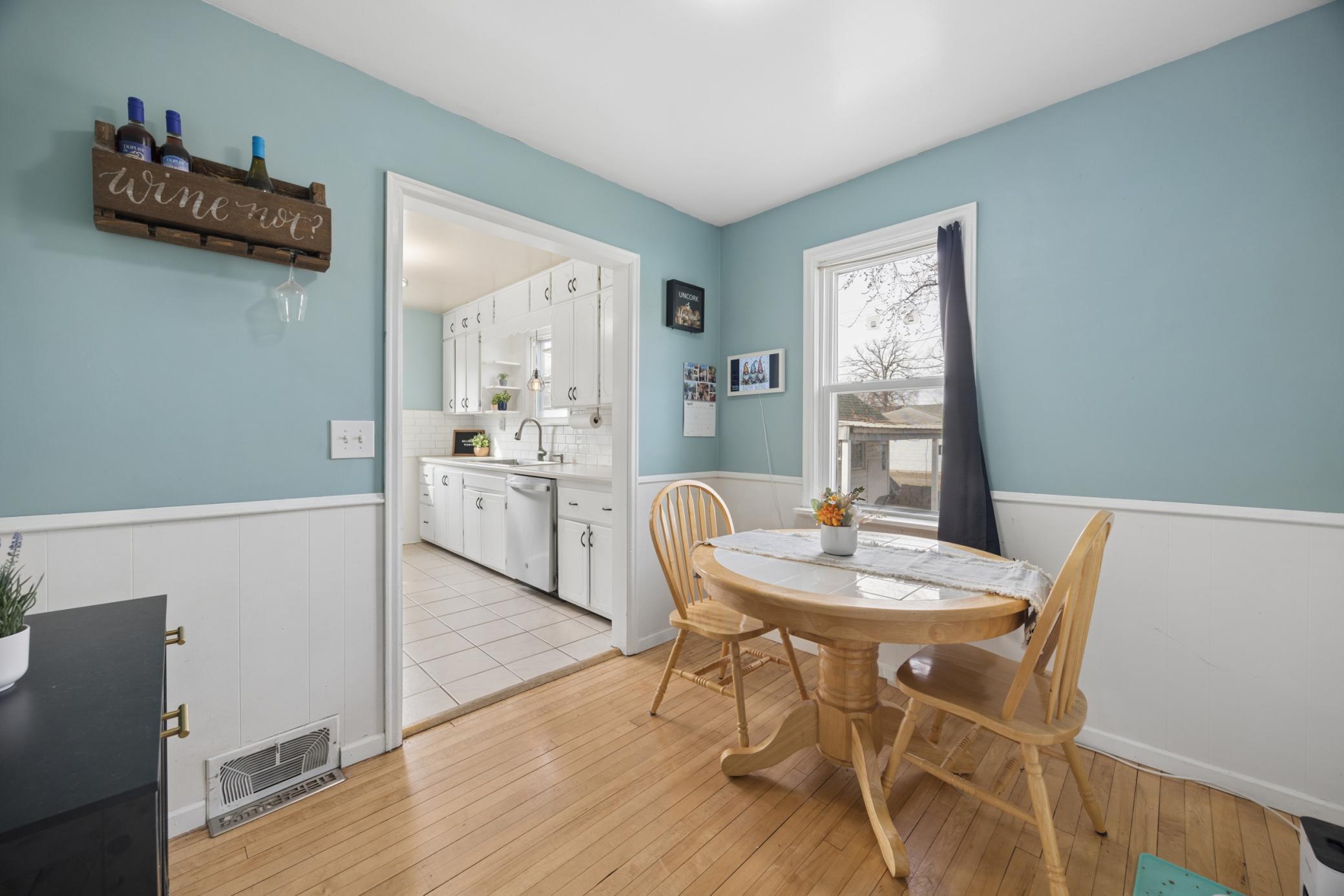 Dining area located right off the kitchen features hardwood floors and a window for backyard viewing