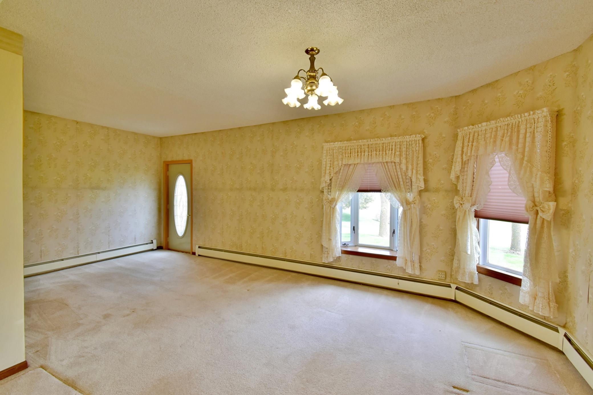 Just inside the front entrance of the house is an open living room area with lots of natural lighting