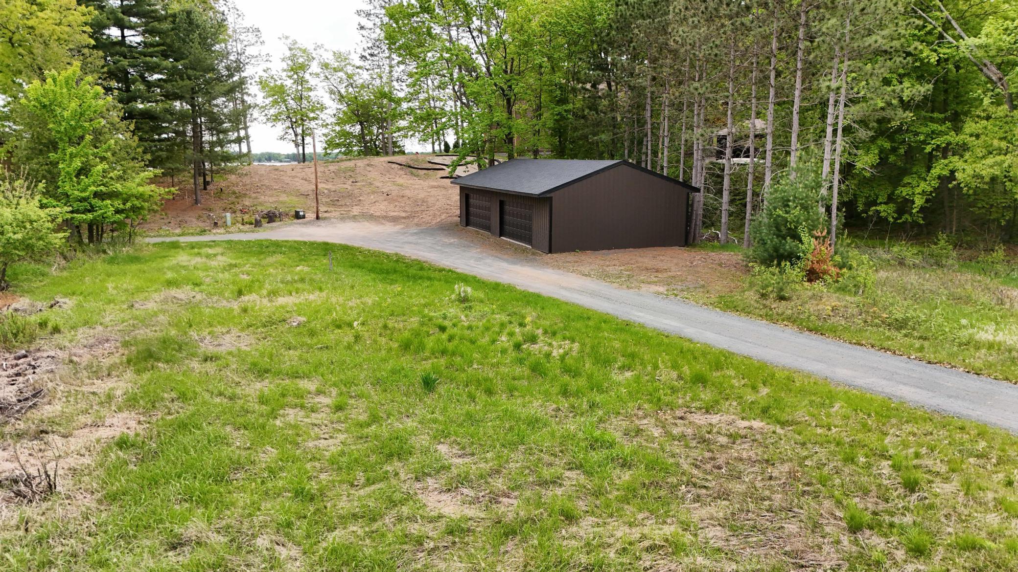 Ideal building site on Sand Lake, complete with 4 car garage, electrical on site, driveway, and gorgeous steps down to the lake. All you need is a vision.