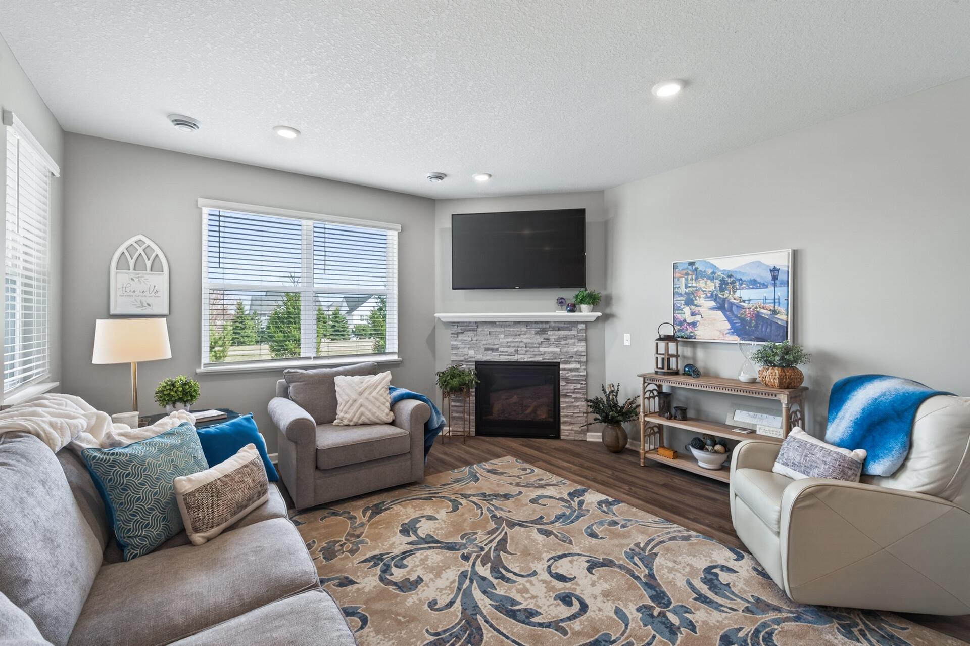Spacious living room with corner gas fireplace with brick surround and wood mantle.
