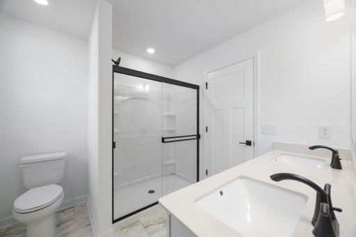 The en-suite bathroom features a sophisticated glass-enclosed shower