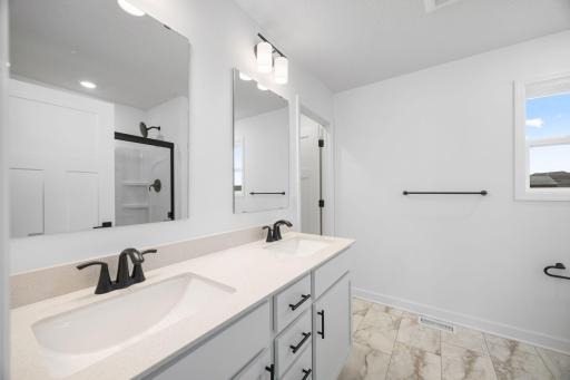 Rectangular dual sinks at this spacious quartz-topped vanity promote streamlined morning routines