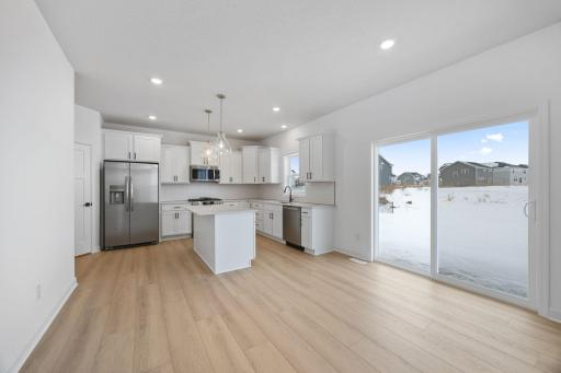 The spacious kitchen features brand-new stainless steel appliances, a center island and ample cabinetry storage.