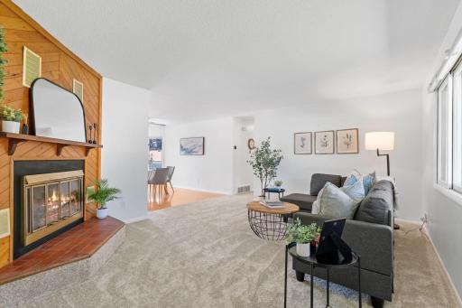 Spacious living room with cozy fireplace, fresh carpet (2025), and an open flow to the dining area â perfect for everyday living and entertaining.