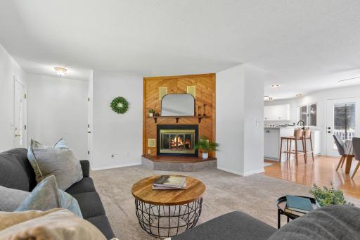 Spacious living area with updated finishes and a cozy wood burning fireplace as the focal point.