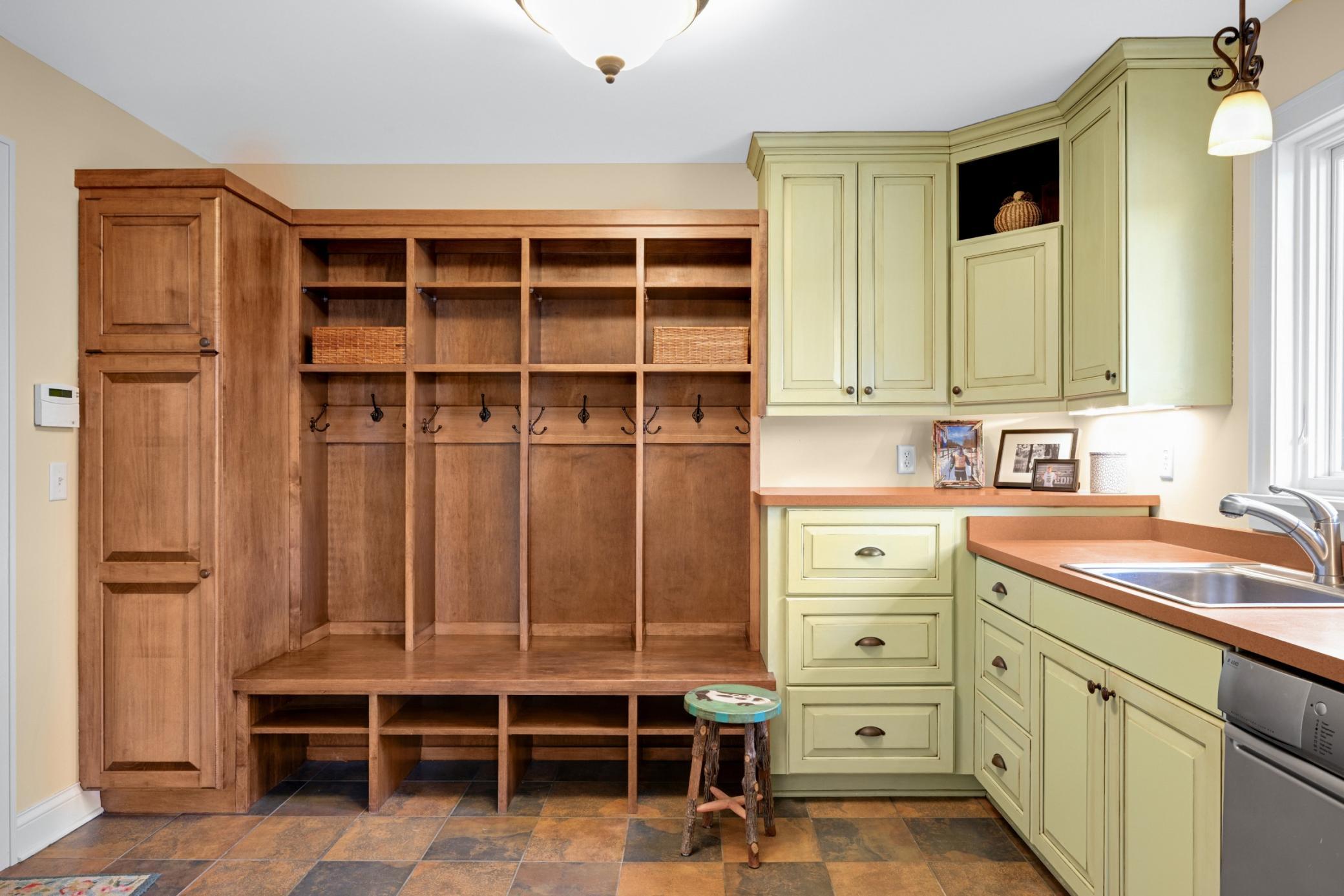 A generous mudroom/ laundry room offers an Asko washer & dryer, four cubbies, plenty of cabinets and connects seamlessly to the finished oversized, heated two+ car garage