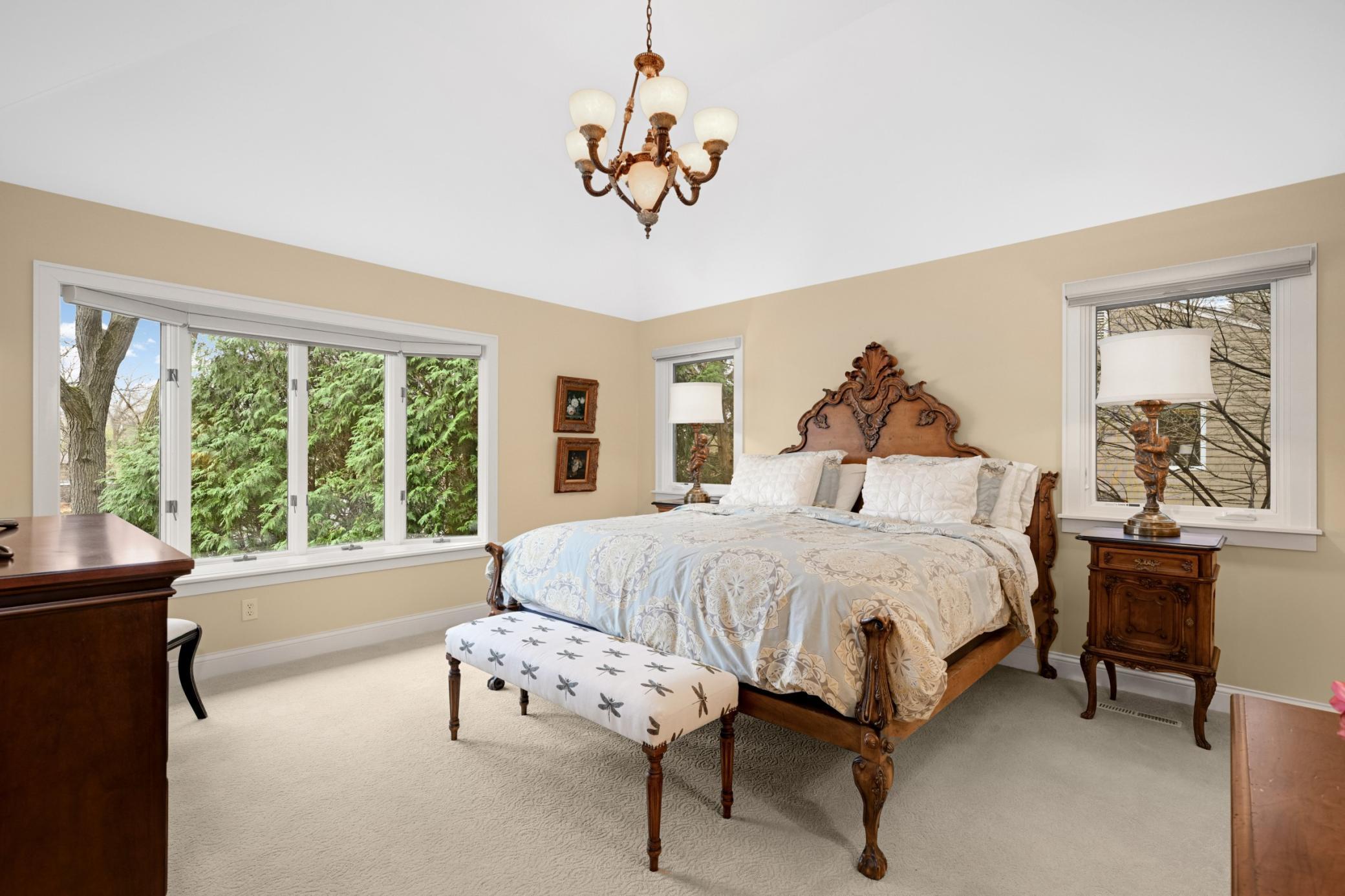 To the left is a light-filled spacious vaulted primary bedroom