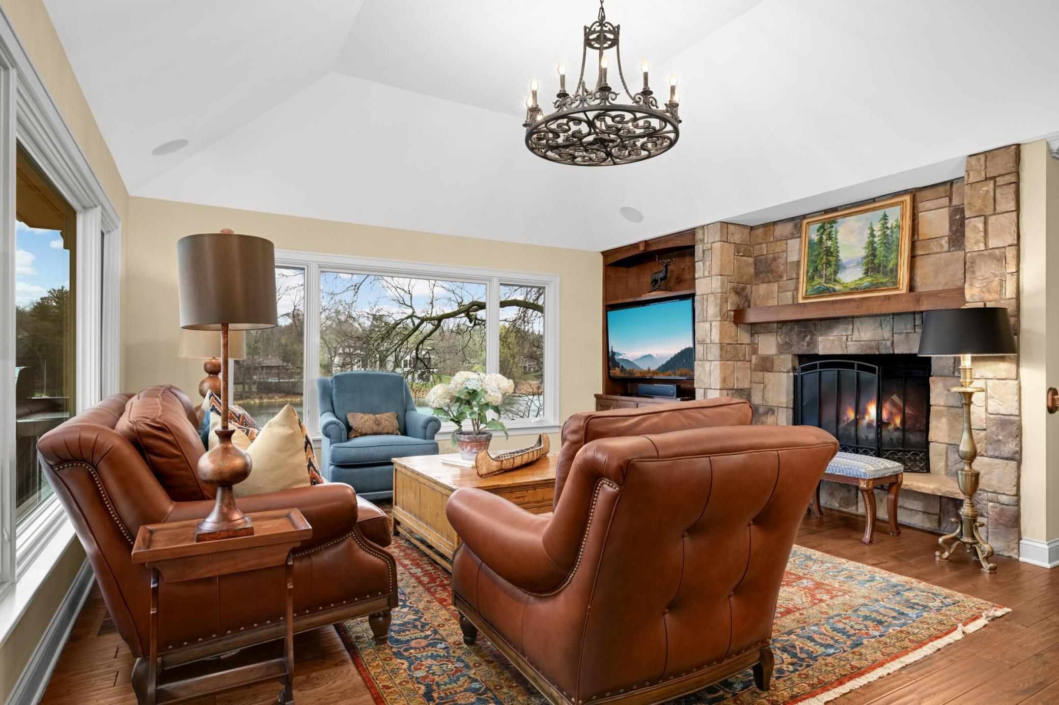 A large wood-burning fireplace with a hand selected stone surround, and newly added tv cabinet