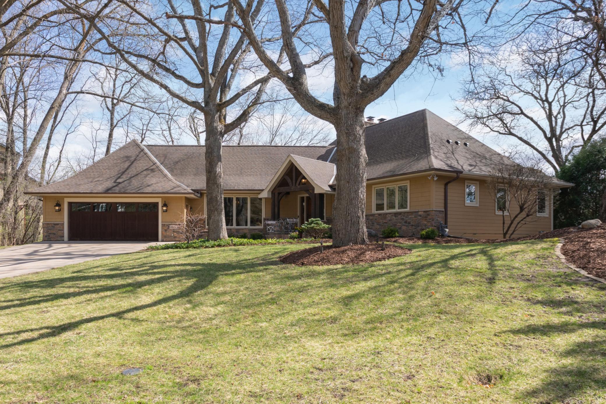 Excellent curb appeal with stone and cedar shingle siding, copper gutters and a remodeled French chateau styled raised roof.