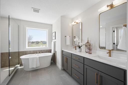Spa-like primary bathroom with free-standing tub, beautiful cabinetry and tilework!