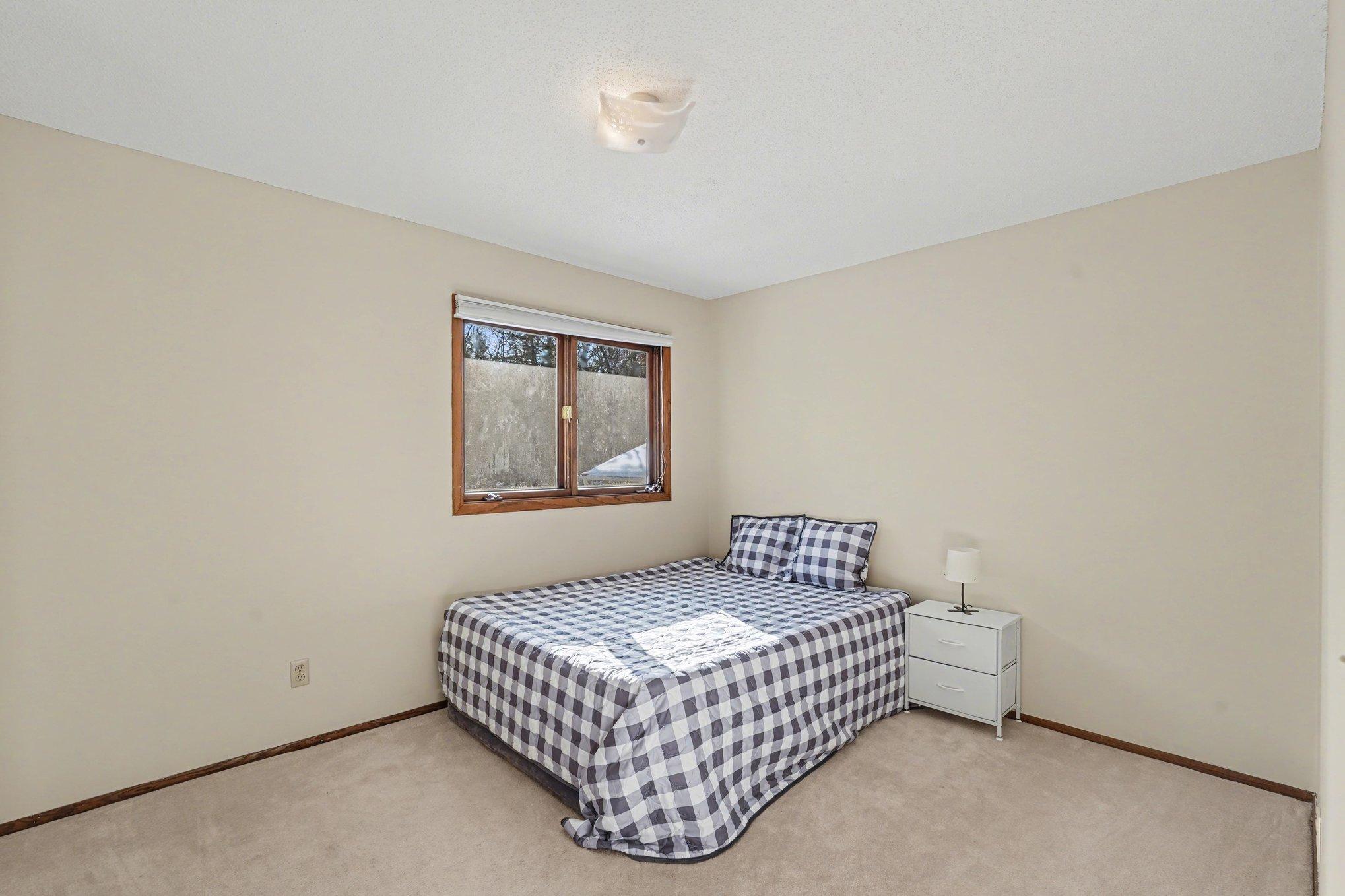 A bright and airy second bedroom on the upper level! Features a large window for abundant sunlight and a spacious closet. Perfect for guests, family, or a home office.